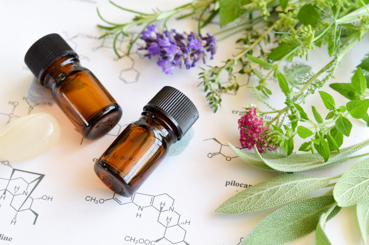 Aromatherapy oils in brown bottes surrounded with plants.