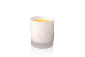 Orange scented candle in white Petits Rituels glass.